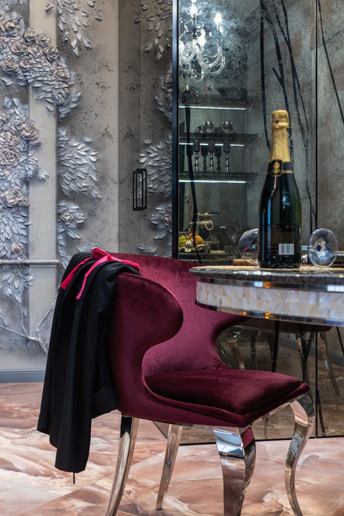 Interior of contemporary fancy living room with creative purple armchair near round table with bottle of champagne